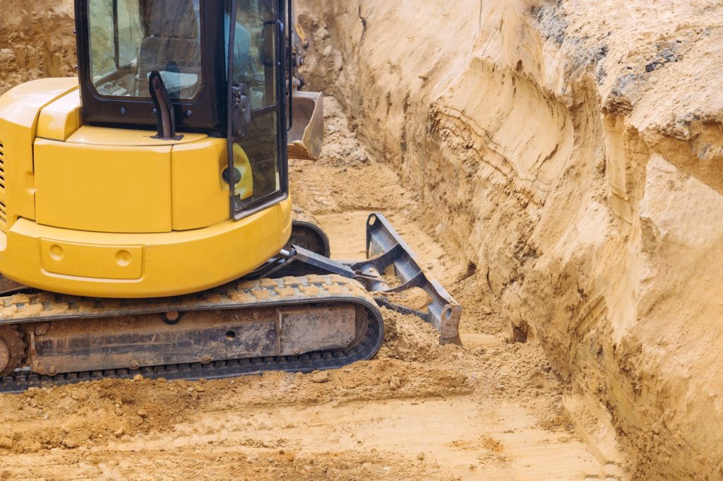 Excavator for ground prepared for pouring the foundation, professional level of ground works in outdoors construction