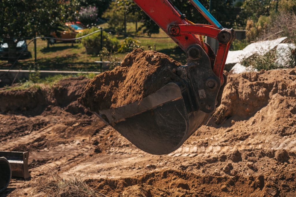 Excavator shovel digging on dirt on a construction site
